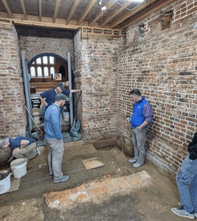 American Heritage Partners Announces Grant to Jamestown Rediscovery, people standing inside a building the historic Jamestown.